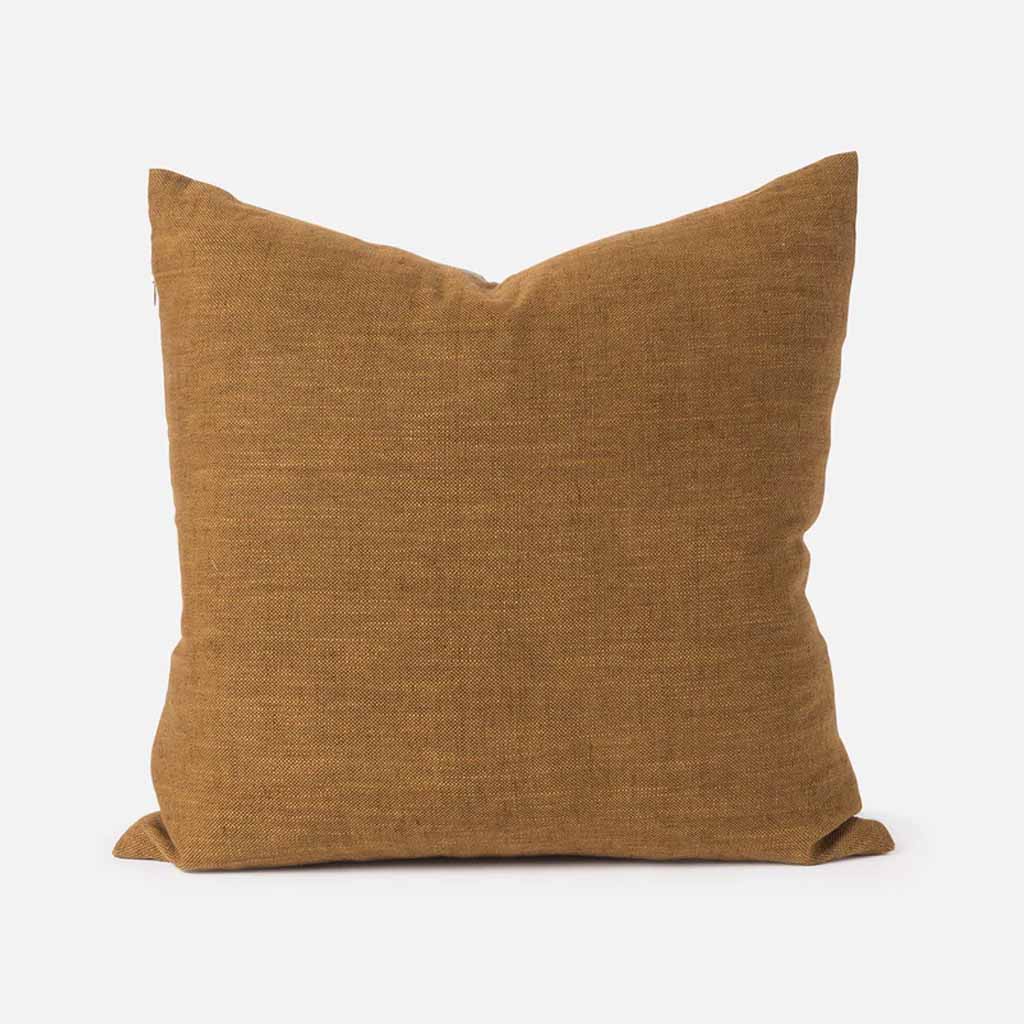 The Bluff Cushion Cover features a constructed patchwork that celebrates the organic forms found in nature. The design reveals an abstract landscape, reminiscent of a New Zealand bluff.